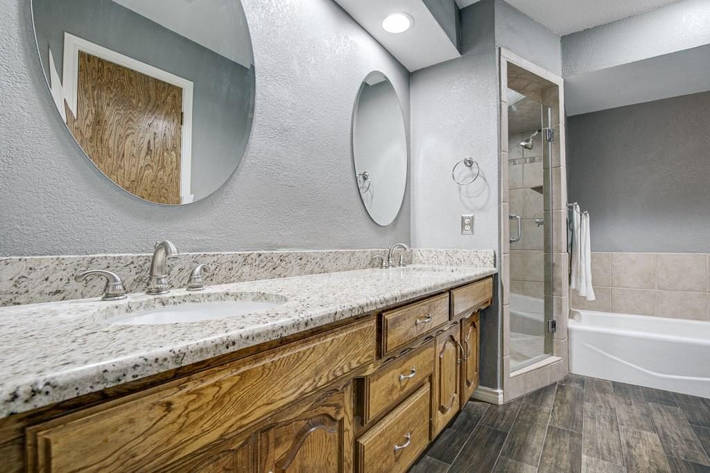 Before: oak vanity, granite counters, gray walls, tub-shower combination