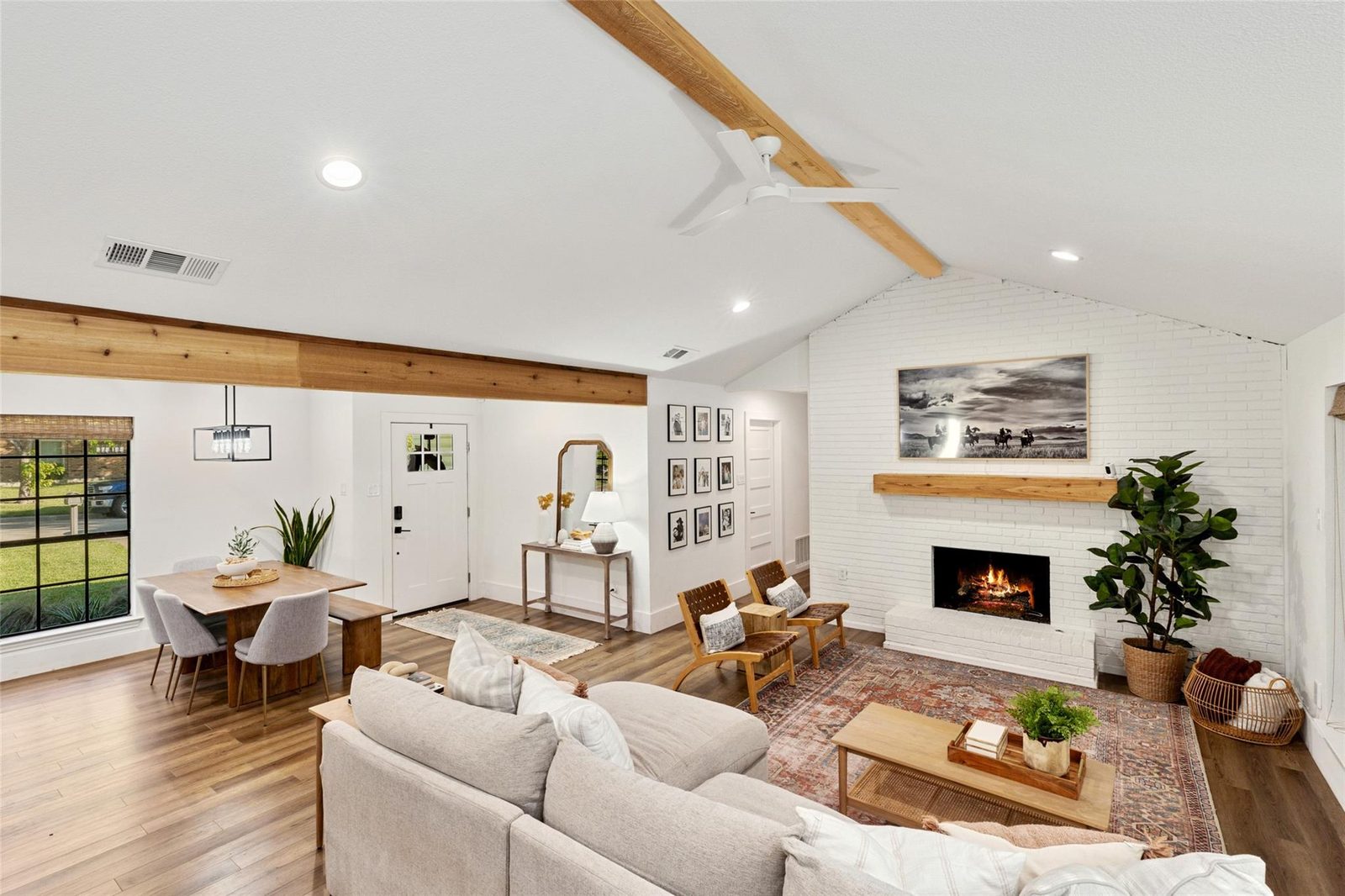 After: white brick, cedar mantel, vintage-style rug and leather chairs