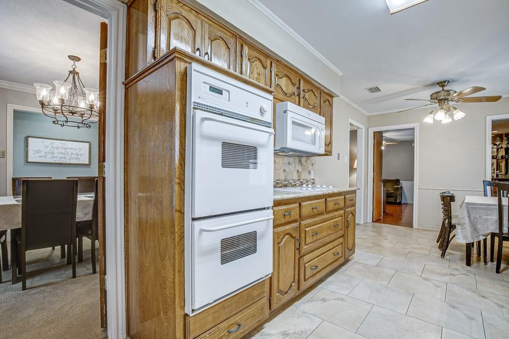 Before: double wall ovens, oak cabinetry, dining room closed off